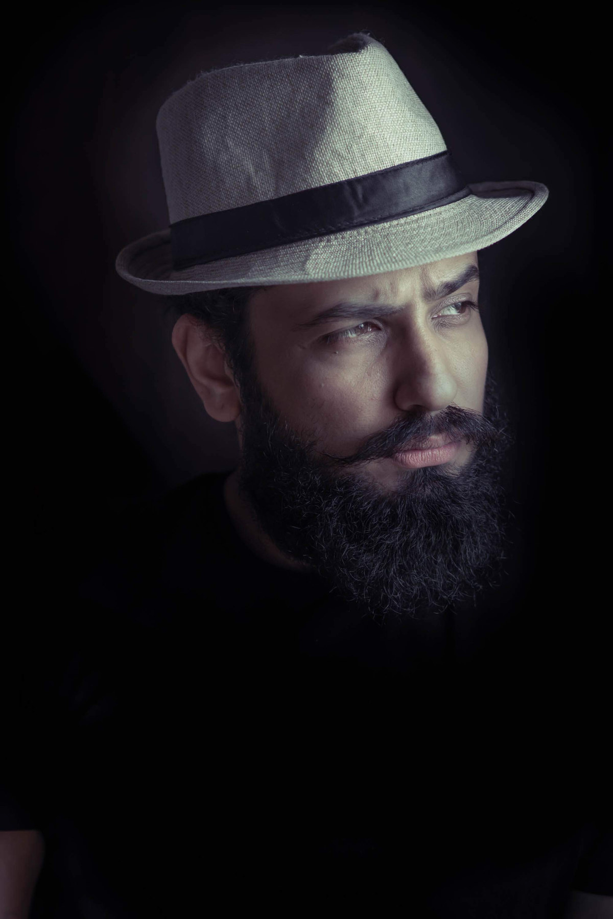 Man in a hat, moody low-key portrait