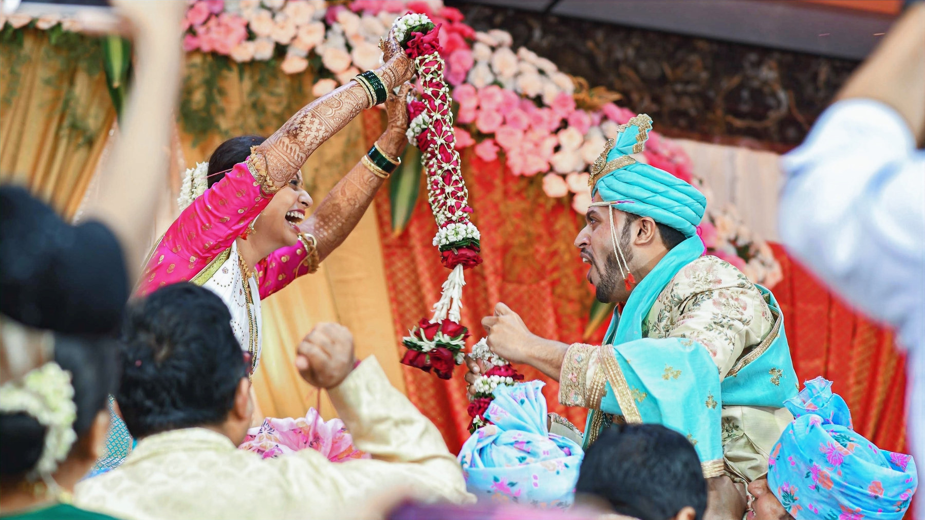 Garland exchange, bride in pink, groom in teal turban